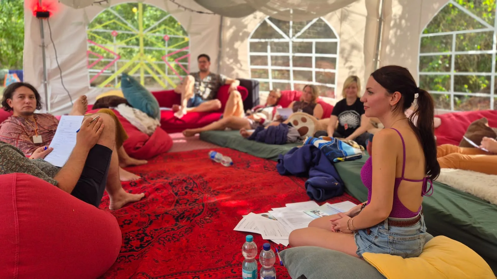 Workshop circle in a festival tent on cushions, beanbags and mattresses