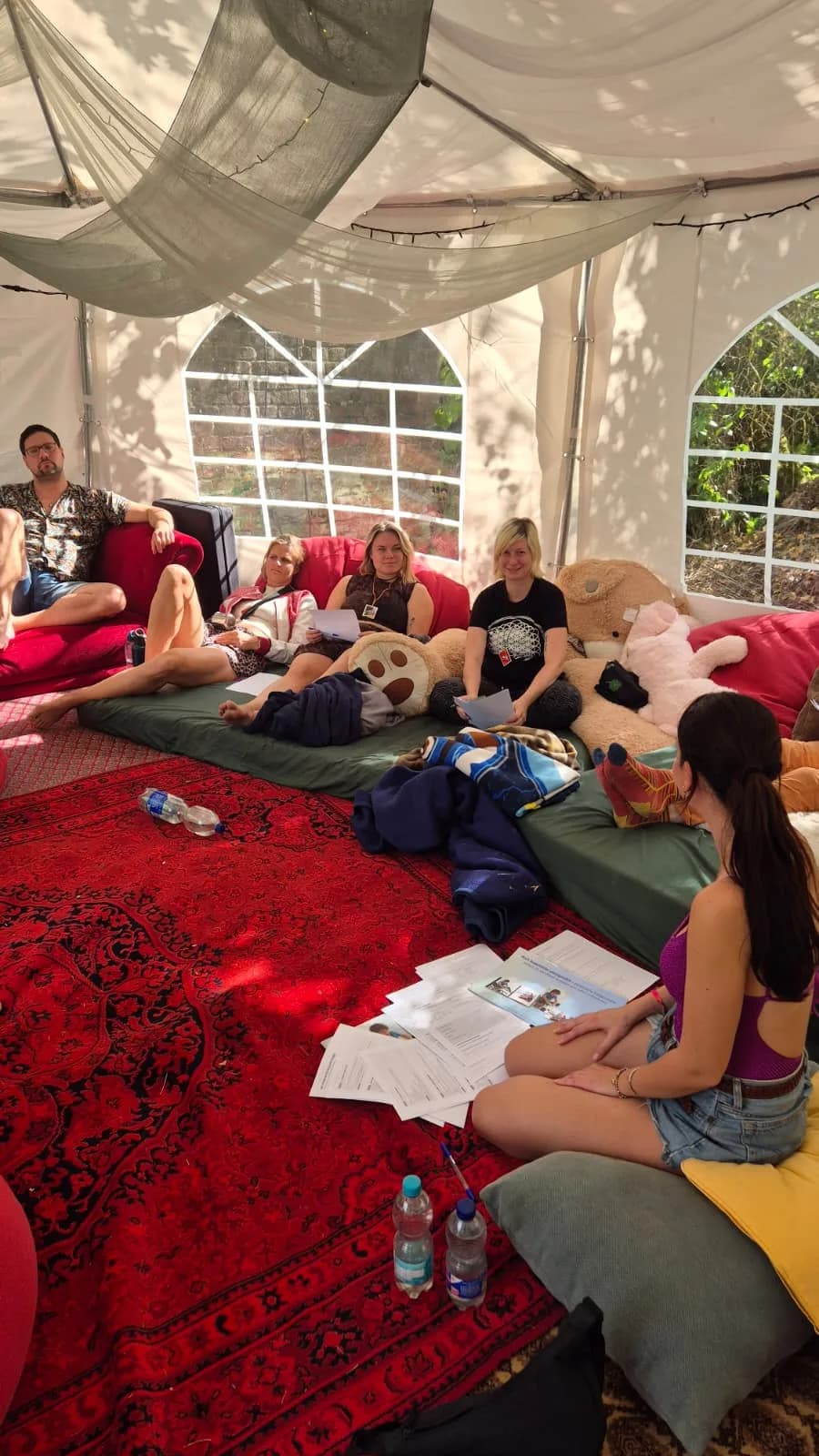 Participants in the tent under draped fabric and fairy lights